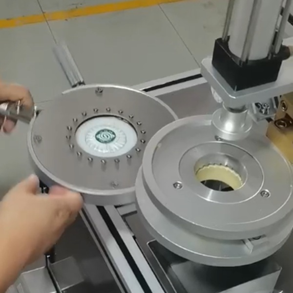 Close-up of pneumatic soap packing machine mold wrapping round hotel soap with pleated film