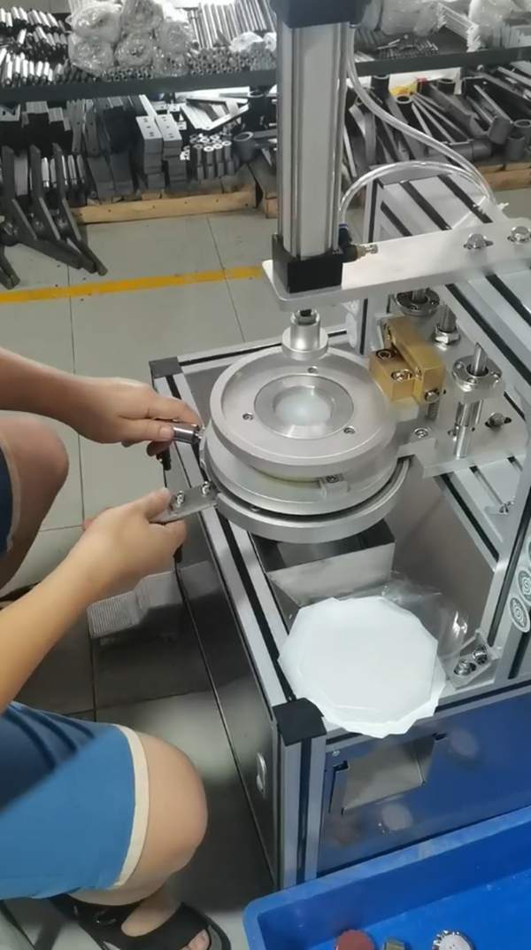 Operator using semi automatic pneumatic soap packing machine to wrap round hotel soaps