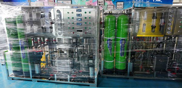 RO pure water treatment machines wrapped in plastic film for delivery